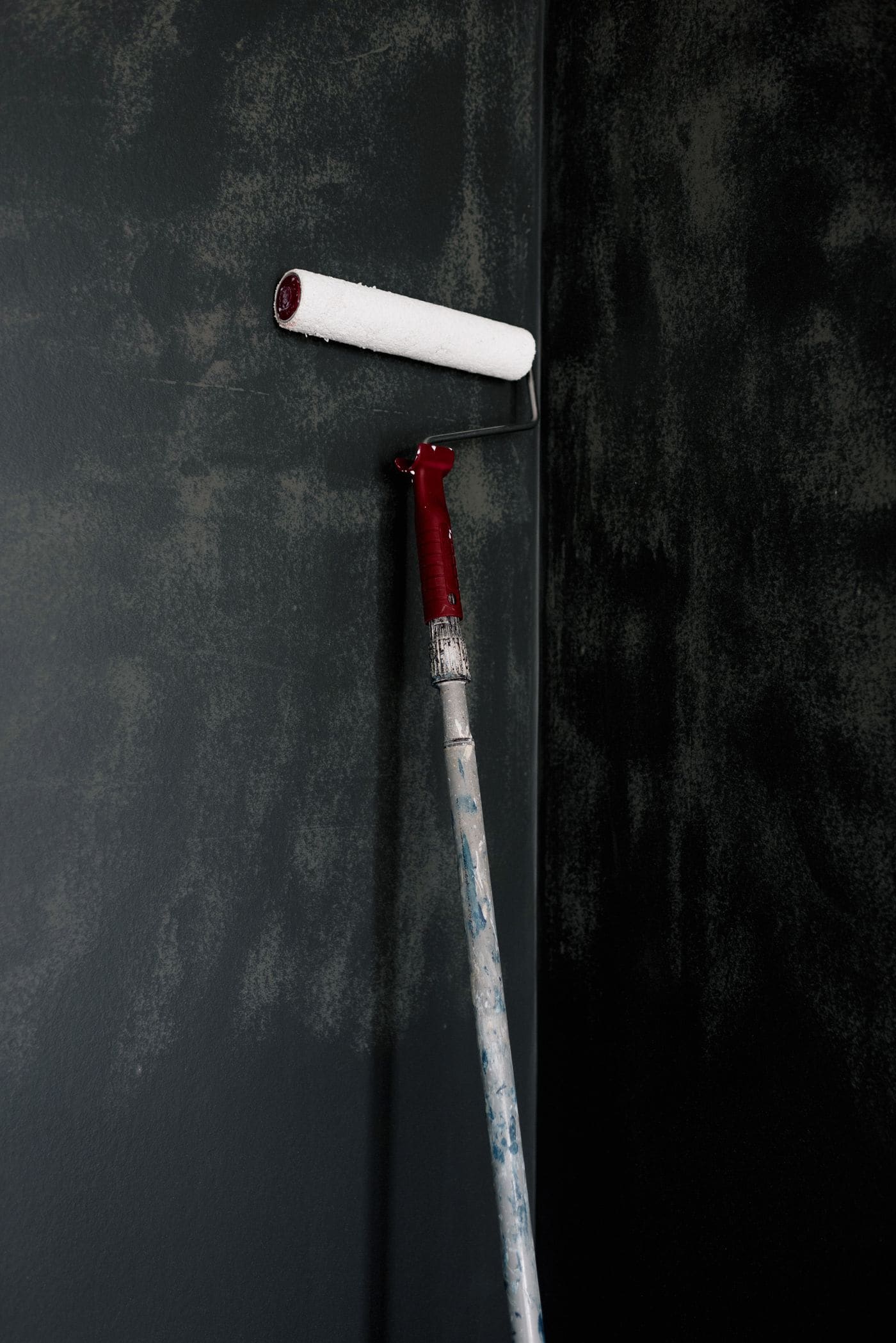Paint roller applying a fresh coat to an interior wall, shown as representative painting imagery
