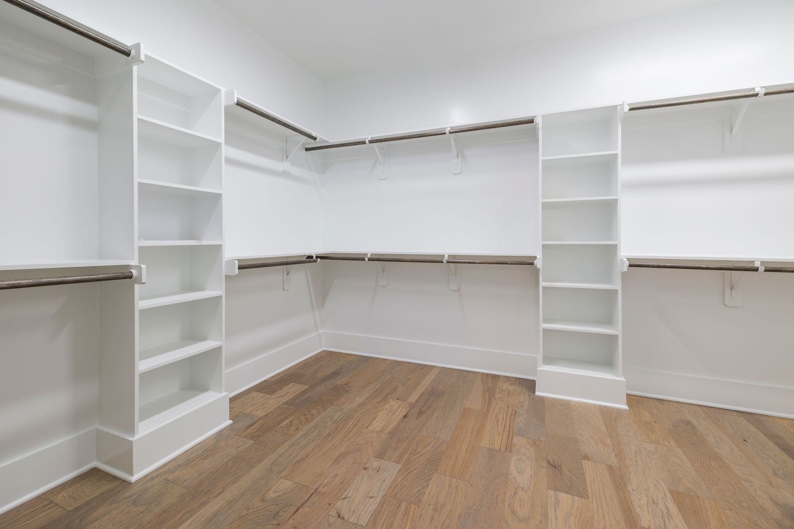 Bright walk-in closet with white built-in shelving, shown as representative closet imagery